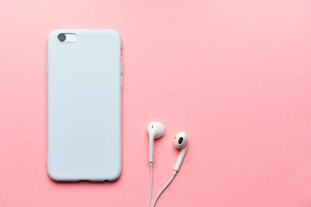 istock White smartphone with headphones on a pink background with copy space. 1255886177