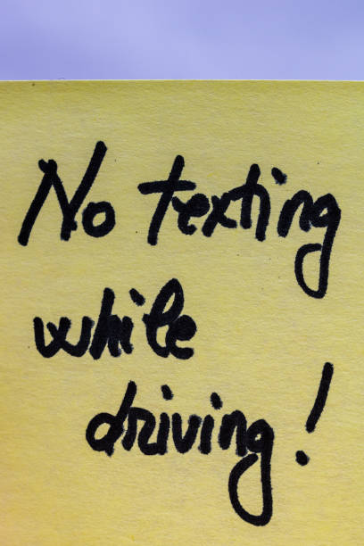 istock No texting while driving handwriting text close up isolated on yellow paper with copy space. 1255887035