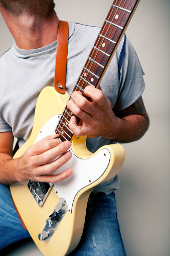 Man playing electric guitar  on solo on white background