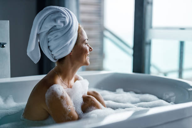 istock Happy woman enjoying in her bubble bath. 1255889834