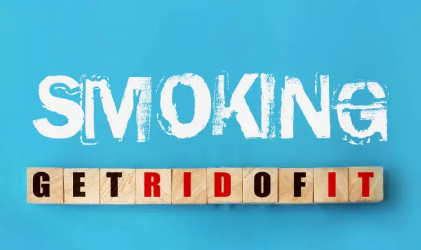 phrase Smoking - get rid of it on sky blue background and on wooden cubes with letters. Top view. Fight Addictions concept