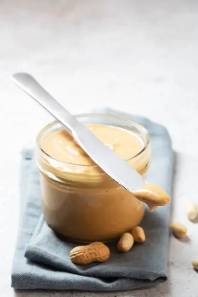 Peanut butter in a glass jar prepared for breakfast. It is rich in several nutrients, including protein and magnesium, which may help protect the heart and manage blood sugar and body weight