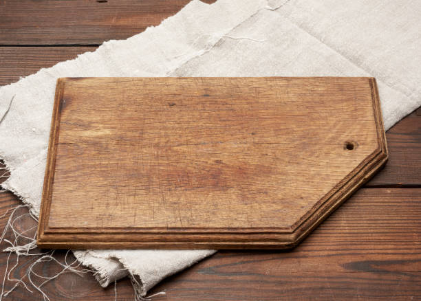 istock old brown rectangular wooden kitchen cutting board and gray linen napkin on the table 1255890331
