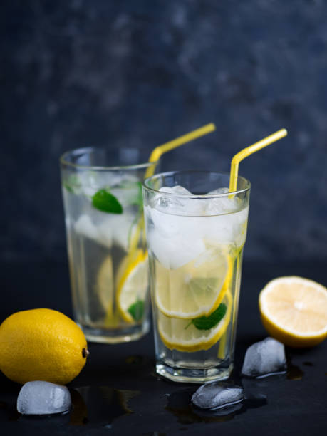 istock A glass of summer lemonade with lemon, mint, ice on a dark concrete table 1255890352