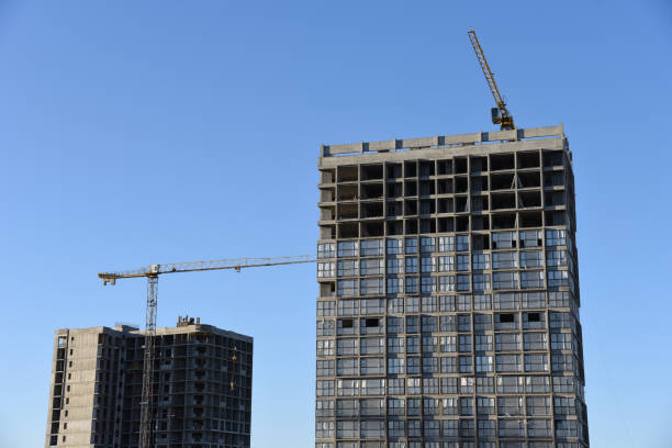istock Tower crane working at construction site on blue sky background with white clouds 1255890354