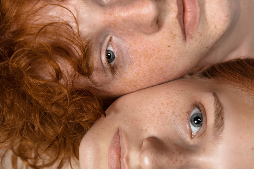 Faces. Fashion portrait of beautiful redhead couple isolated on grey studio background. Concept of male beauty, skin care, fashion and style. Artwork, modern and trendy portrait. Attractive models.