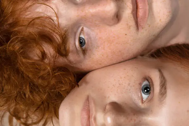 Photo of Portrait of beautiful redhead couple isolated on grey studio background. Concept of beauty, skin care, fashion and style