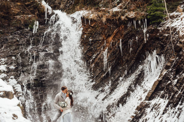 istock bride and groom on the mountain waterfall 1255892648
