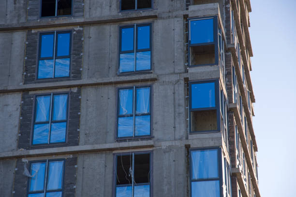 Installation of double-glazed windows in a multi-storey building at a construction site. Glazed window systems with uPVC frames. Housing Renovation Program