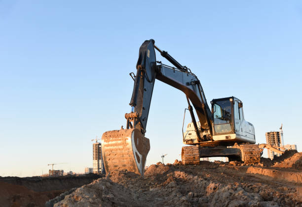 istock Excavator during earthmoving at construction site. Backhoe digg ground at construction site for the construction of the road and laying sewer pipes district heating 1255898965