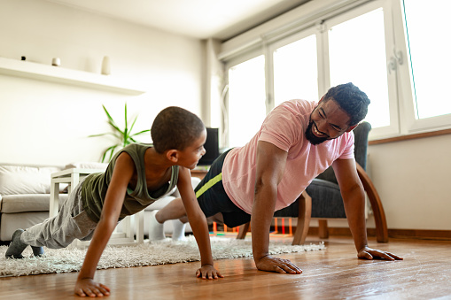 Father and son, home exercising during the pandemic isolation. Belgrade, Serbia