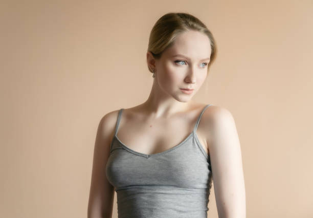 istock Woman posing against beige wall. 1255901693