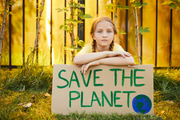 istock Red Haired Girl Holding Save the Planet Sign 1255903561