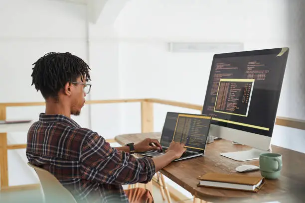 Photo of African Computer Programmer Writing Code