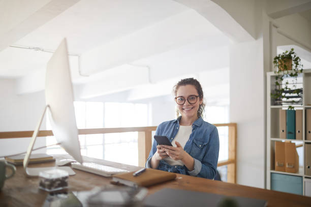 istock Smiling Young Woman Enjoying Work in Office 1255905265