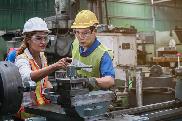 man and woman engineer industry worker wearing hard hat in factory, - performance examining occupation discussion imagens e fotografias de stock