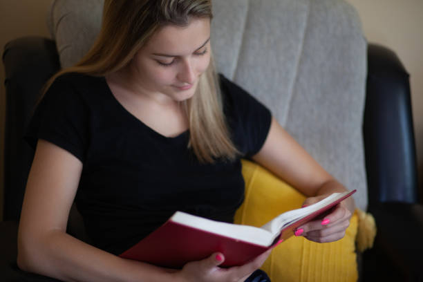 istock Young woman reading a book and enjoying in weekend 1255906864