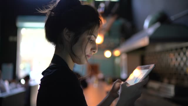 Portrait of a waitress / owner using digital tablet at restaurant