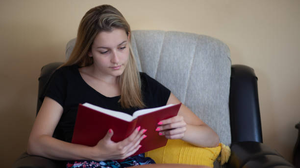 istock Young woman reading a book and enjoying in weekend 1255909900