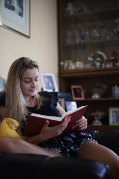 istock Young woman reading a book and enjoying in weekend 1255910761