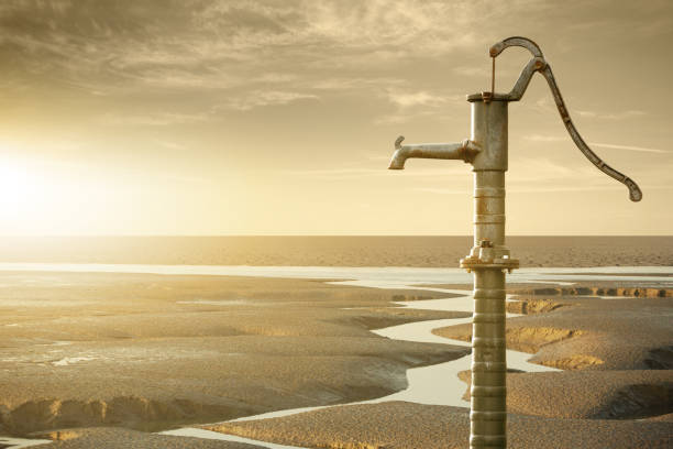 velha bomba de água enferrujada em um rio seco - drought scarcity desert dry - fotografias e filmes do acervo