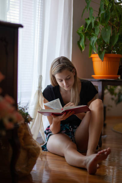 istock Young woman reading a book and enjoying in weekend 1255910818