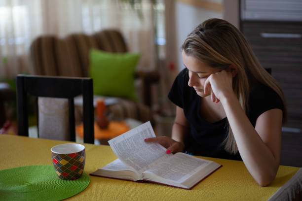 istock Young woman reading a book and drink coffee 1255910861