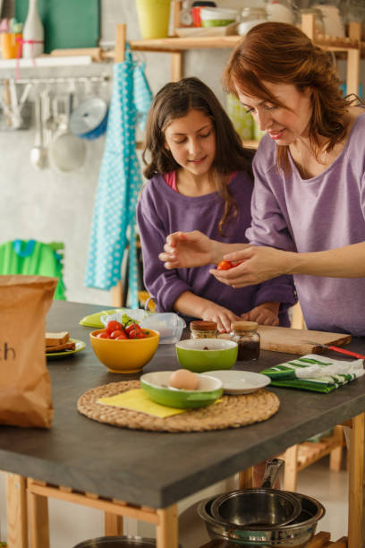 istock Mother making a sandwich for her daughter to take to school 1255911821
