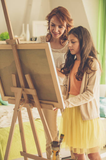 istock Mother and daughter bonding while painting together 1255912111