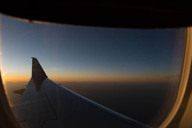 airplane wing during sunset flight - wing airplane window sunset imagens e fotografias de stock