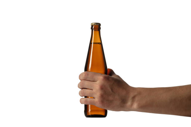 istock Empty golden colored beer bottle in male hand. Isolated on white studio background 1255916242
