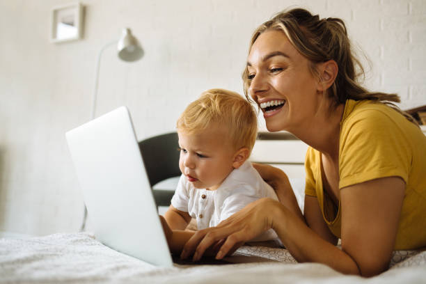 istock Caring mother and son using laptop on bed 1255918711