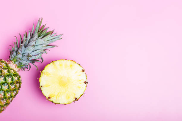 istock Fresh ripe pineapple and sliced pineapple on a pink background. 1255918727
