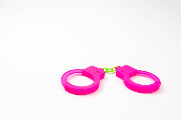 istock The toy handcuffs are pink on a white background. 1255918868