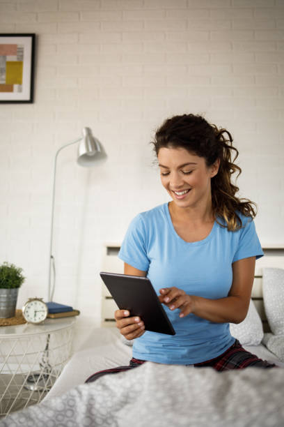istock Woman using digital tablet in bedroom 1255918911