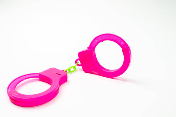 istock The toy handcuffs are pink on a white background. 1255918934