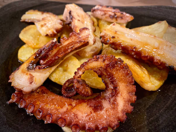 istock Grilled whole octopus on a plate. Black background. Top view 1255919930