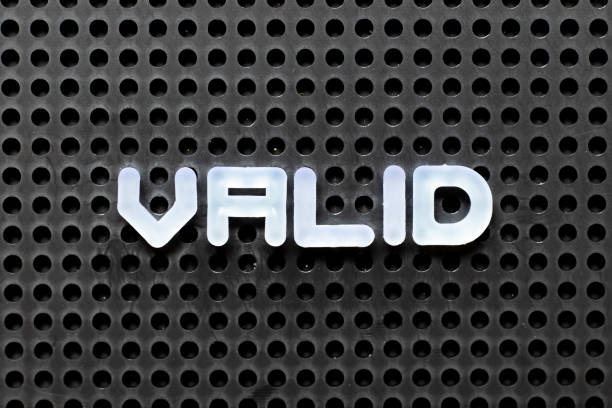 istock White color alphabet with word valid on black pegboard background 1255920886