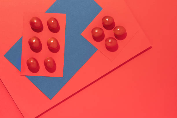 istock Cherry tomatoes abstract on geometrical red and blue colored background, studio shot with copy space - Food knolling concepts. 1255922010