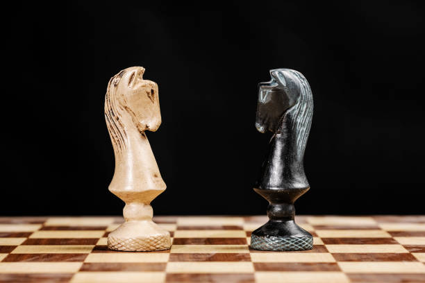 istock pieces of knights facing each other on a chessboard against a black background 1255924903