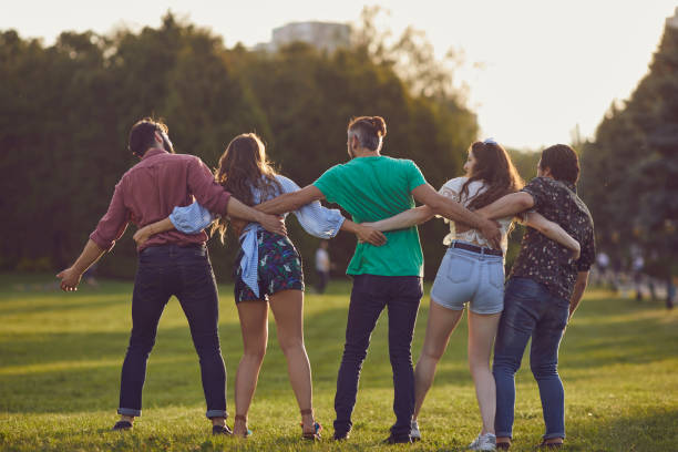 istock Happy student friends spending time together outdoors. Young hipsters having great time in countryside 1255926512