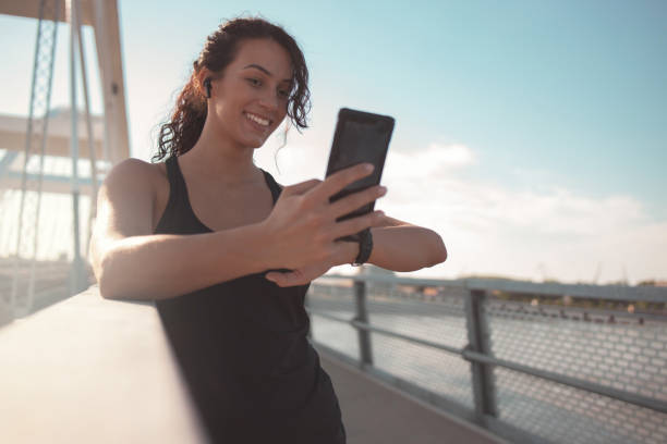 istock Fitness woman using smart phone 1255928058