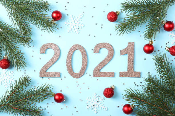 istock Composition with numbers 2021 and Christmas decor on a colored background top view 1255928124