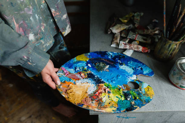 istock The woman holds a palette in her hands at home art studio 1255928155
