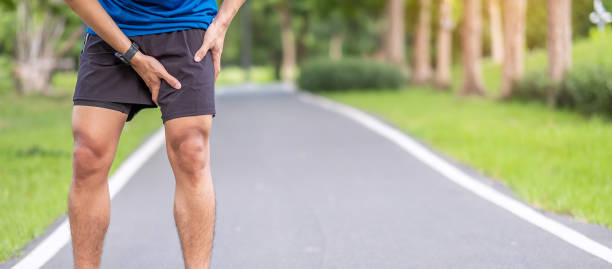 young adult male with muscle pain during running. runner have leg ache due to groin pull. sports injuries and medical concept - physical injury imagens e fotografias de stock