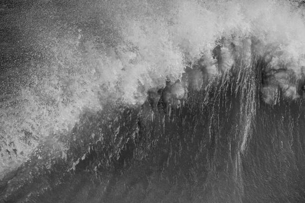 istock Amzing image of individual wave breaking and cresting during violent windy storm in black and white with superb detail 1255930871