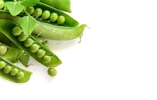 Fresh green peas in pods on a white background. Copy space. Healthy food border, frame, corner