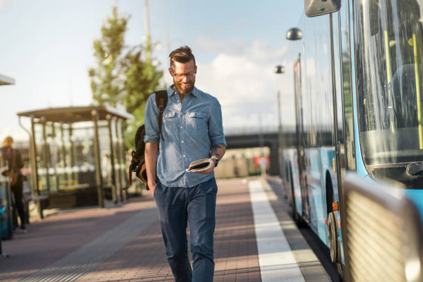 istock Man reading a book at the bus stop 1255931799