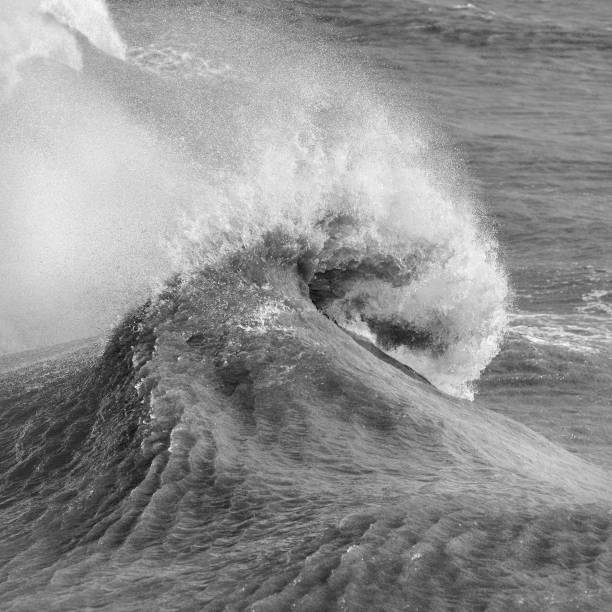 istock Amzing image of individual wave breaking and cresting during violent windy storm in black and white with superb detail 1255931939