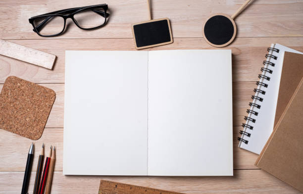 istock Notebook with school supplies,   and blackboard on a wooden table. Top view. Space for text. For back to school 1255932108
